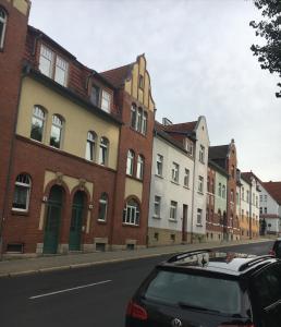 a car parked in front of a row of buildings at Gemütliche Ferienwohnung im Erdgeschoss- Jenaer Straße in Erfurt