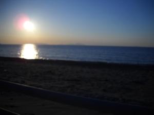 a sunset on the beach with the ocean at Le Formiche in Milazzo