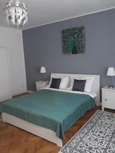 een slaapkamer met een groot bed en een groene deken bij Apartment Bianco Central in Sibiu