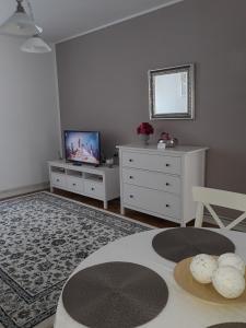 een woonkamer met een tv en een tafel bij Apartment Bianco Central in Sibiu