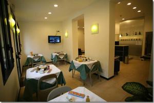 un restaurante con 2 mesas con manteles verdes en Hotel Paradiso en Milán