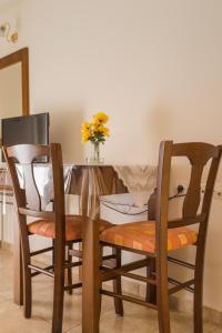 a dining room table with two chairs and a vase of flowers at Vrokastro Apartments in Istro