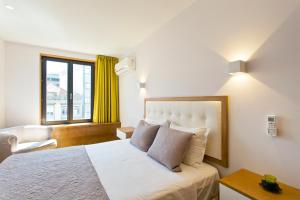 um quarto com uma cama, uma cadeira e uma janela em OTF- Porto Centro no Porto