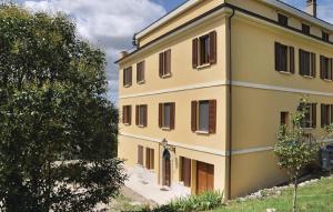 un edificio amarillo con persianas marrones en Agriturismo Villa Val D'Olivi en Capodacqua