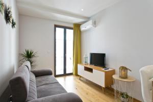 a living room with a couch and a tv at OTF- Porto Centro in Porto