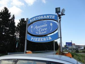 um sinal para uma pizzaria num parque de estacionamento em Anema e core em Pizzo