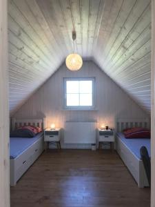 Zimmer im Dachgeschoss mit 2 Betten und 2 Tischen in der Unterkunft Skandinavisches Ferienhaus 2. Reihe zum Wasser für 6 Personen  in Zerpenschleuse