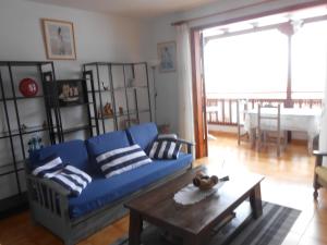 サンティアゴ・デル・テイデにあるBELLE VUE sur les FALAISESのリビングルーム(青いソファ、コーヒーテーブル付)