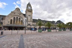 a large stone building with a clock tower on it at Grand Appartement Vue Cathédrale in Metz