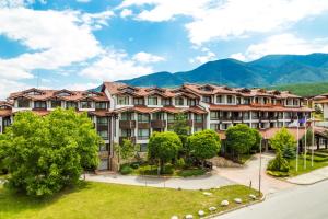 an apartment building with mountains in the background at Hotel Perun Lodge in Bansko