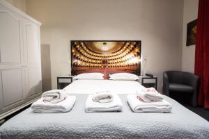 a bedroom with a bed with towels on it at Hôtel Les Voyageurs in Bastia