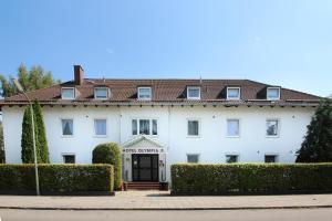 a white building with a door and bushes at Hotel Olympia in Munich