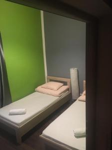 two bunk beds in a room with a green wall at One World Hostel in Krakow