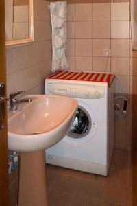 a washing machine in a bathroom with a sink at Our parent's house. Family house for rent in Skala Kallirakhis +57 photos