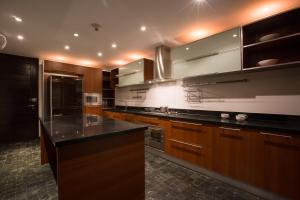 eine Küche mit Holzschränken und einer schwarzen Arbeitsplatte in der Unterkunft Villa Princess Stephanie in Kata Beach