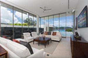 a living room with white furniture and large windows at Villa Princess Stephanie in Kata Beach