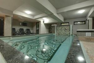 a swimming pool in a hotel room with a glass pool at 6aTo Hotel & Spa in Sofia