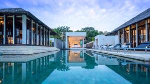 a swimming pool in front of a house at Villa Princess Stephanie in Kata Beach