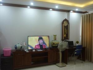a living room with a tv and a grandfather clock at Asia Apartment Hotel Bac Ninh in Bắc Ninh