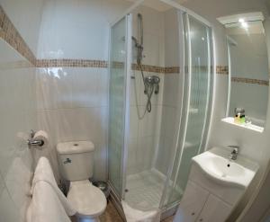 a bathroom with a shower and a toilet and a sink at Thomas James Hotel in Leamington Spa