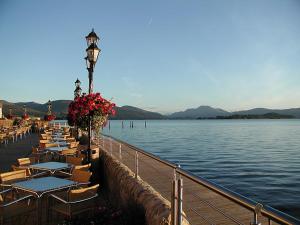 una fila de mesas y sillas junto a un cuerpo de agua en Duck Bay Hotel & Restaurant, en Balloch