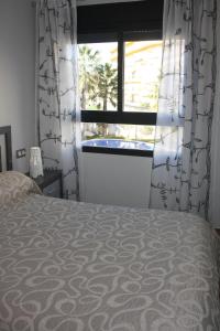 モライラにあるApartamento Relax Morairaのベッドルーム1室(ベッド1台付)、窓(カーテン付)