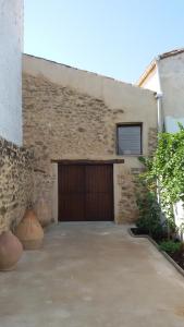 un garaje con una puerta de garaje marrón y un edificio en Casa Rural Las Camilas- Sierra de Alcaraz, en Vianos