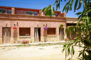 un edificio antiguo con flores en las ventanas en Las Casitas de los Mata en Landete