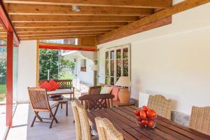 - une terrasse couverte avec une table et des chaises en bois ainsi qu'une table avec des fruits dans l'établissement La Torrentera de Cantabria, à Rada