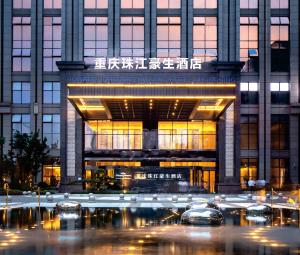 ein großes Gebäude mit davor geparkt in der Unterkunft Howard Johnson Zhujiang Hotel Chongqing in Chongqing