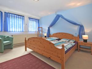 ブラウンラーゲにあるSpacious holiday home near the ski areaのベッドルーム1室(青い天蓋付きの木製ベッド1台付)