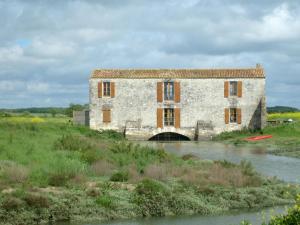 an old stone building with a bridge over a river at Maison Confortable WI-FI Animaux oui in Marennes