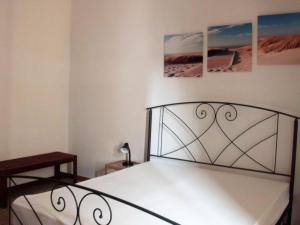 a bed in a bedroom with two pictures on the wall at Appartamenti Dalì in Bernalda
