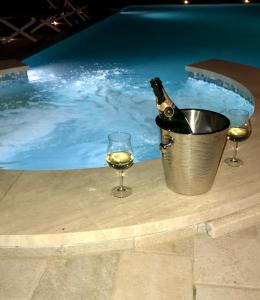 una botella de champán y una copa junto a la piscina en Villa Ester en Camaiore