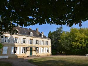 um grande edifício branco com um telhado preto em Vintage Mansion in Saint Aubin sur Loire with Pool em Bourbon-Lancy