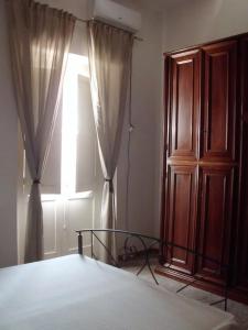 a bedroom with a bed and a window with curtains at Appartamenti Dalì in Bernalda