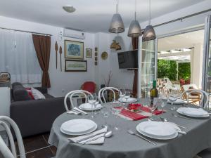 a dining room table with plates and wine glasses at Spacious Holiday Home in Molat with Pool in Brgulje