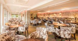 um restaurante com mesas e cadeiras num quarto em Duck Bay Hotel & Restaurant em Balloch