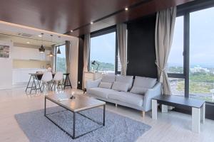 a living room with a couch and a table at Cozy Living Sky Apartment in Kota Kinabalu