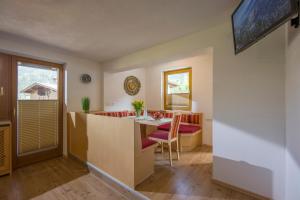 uma cozinha e sala de estar com mesa e cadeiras em Berghof Geisler em Finkenberg