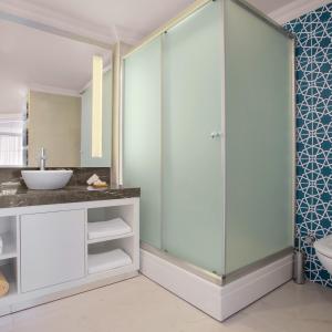 a bathroom with a glass shower and a sink at Paloma Marina Suites - Adult Only in Kuşadası