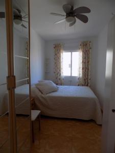 トレビエハにあるSonnenscheinのベッドルーム1室(ベッド1台、天井ファン、鏡付)