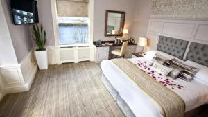 um quarto com uma cama, uma secretária e uma janela em The Lakeside Hotel & Leisure Centre em Killaloe