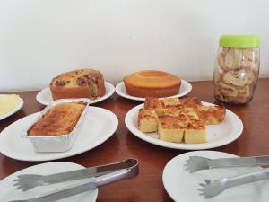 a table topped with plates of cakes and pastries at Hotel Legal in Capanema