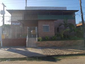 un bâtiment en brique avec une porte devant lui dans l'établissement Hotel Legal, à Capanema