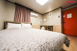 ein Schlafzimmer mit einem großen Bett und einer roten Tür in der Unterkunft Insadong R Guesthouse in Seoul