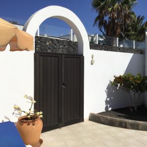 Sol y Luna Room & Suite Lanzarote Holidays في بلايا بلانكا: باب في مبنى أبيض بجدار حجري