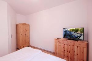 ビンツにあるHaus Meinert by Rujanaのベッドルーム1室(ベッド1台、木製キャビネット内のテレビ付)