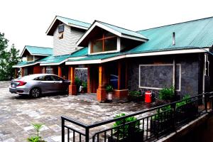 a car parked in front of a house at Hilla Apartments Nathia Gali in Abbottābād