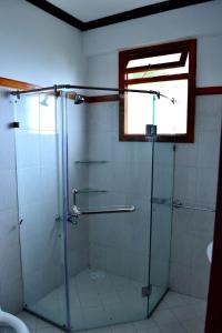 y baño con ducha de cristal y ventana. en Hilla Apartments Nathia Gali, en Abbottābād